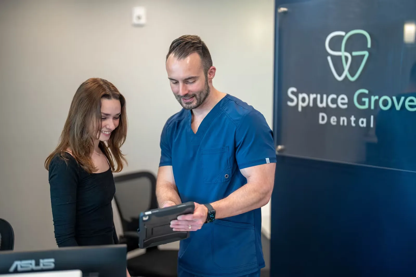 Spruce Grove Dental team reviewing a patient chart on a tablet