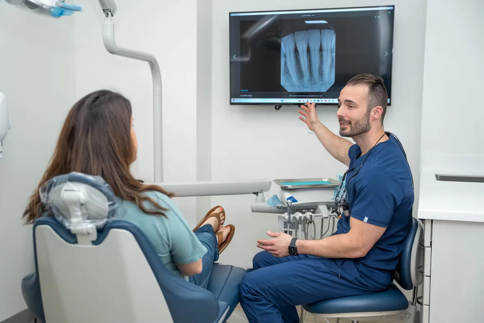 Dr. Jonathan Adler reviewing a digital X-ray on screen with a patient